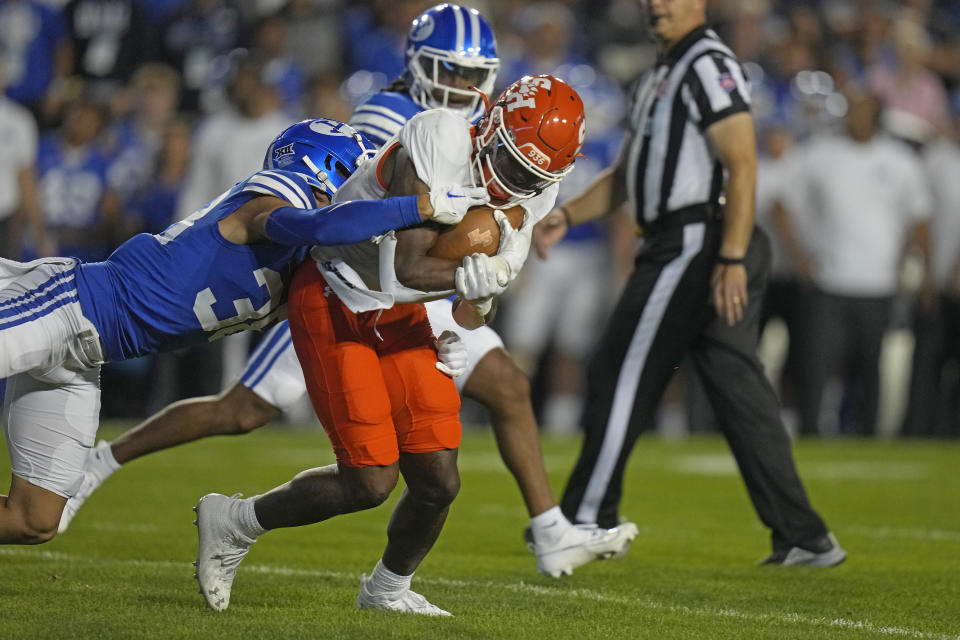 BYU safety Crew Wakley, left, tackles Sam Houston State running back John Gentry during the first half of an NCAA college football game Saturday, Sept. 2, 2023, in Provo, Utah. (AP Photo/Rick Bowmer)
