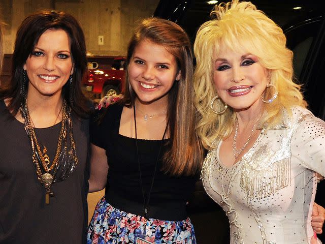 <p>Rick Diamond/Getty</p> Martina McBride, daughter Emma McBride and Dolly Parton pose backstage at the 2010 We're All For The Hall benefit concert on October 5, 2010 in Nashville, Tennessee.