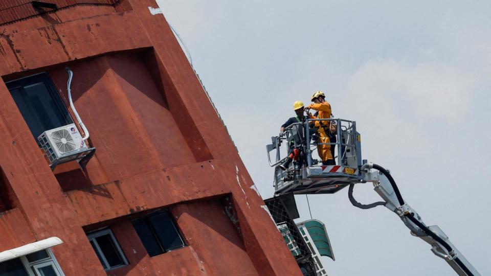 PHOTO: Workers carry out operations while on the elevated platform of a firefighting truck at the site where a building collapsed, following the earthquake, in Hualien, Taiwan, April 4, 2024. (Carlos Garcia Rawlins/Reuters)