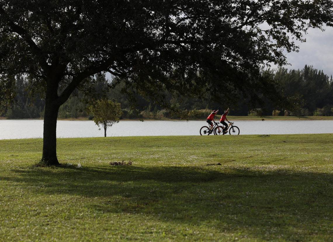 Cyclists pass the lake on a mountain bike trail in Amelia Earhart Park on Dec. 21, 2022.