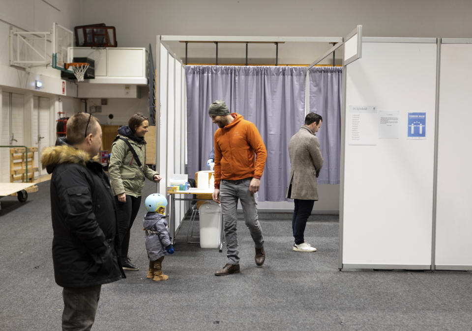 People vote at a local sports complex in Kopavogur, Iceland, Saturday, Sept. 25, 2021. Icelanders are voting in a general election dominated by climate change, with an unprecedented number of political parties likely to win parliamentary seats. (AP Photo/Arni Torfason)