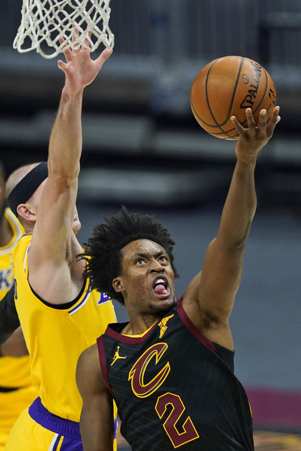 Cleveland Cavaliers' Collin Sexton, right, drives to the basket against Los Angeles Lakers' Alex Caruso in the first half of an NBA basketball game, Monday, Jan. 25, 2021, in Cleveland. (AP Photo/Tony Dejak)