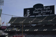 A flag flies at half-staff at Oakland Coliseum during a moment of silence for Supreme Court Justice Ruth Bader Ginsburg before a baseball game between the Oakland Athletics and the San Francisco Giants in Oakland, Calif., Saturday, Sept. 19, 2020. (AP Photo/Jeff Chiu)