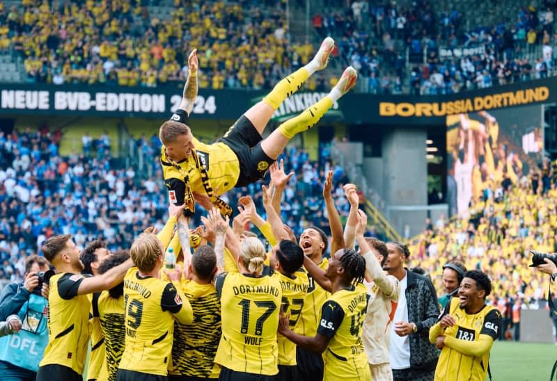 Dortmund's Marco Reus is thrown into the air by his teammates after the German Bundesliga soccer match between Borussia Dortmund and Darmstadt 98 at Signal Iduna Park. Bernd Thissen/dpa