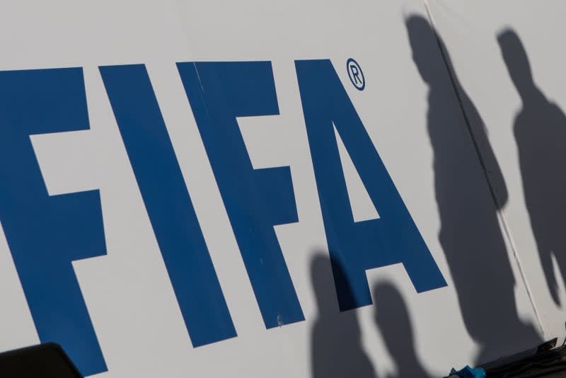 The shadows of spectators can be seen on a FIFA banner. Omar Zoheiry/dpa