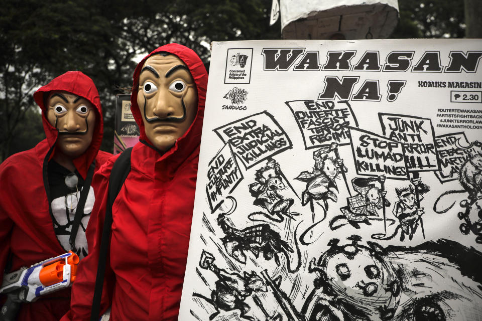 Protesters wear masks as they hold a slogan that says "End Now!" before marching towards the House of Representatives where Philippine President Rodrigo Duterte is set to deliver his final State of the Nation Address in Quezon city, Philippines on Monday, July 26, 2021. Duterte is winding down his six-year term amid a raging pandemic and a battered economy. (AP Photo/Gerard Carreon)