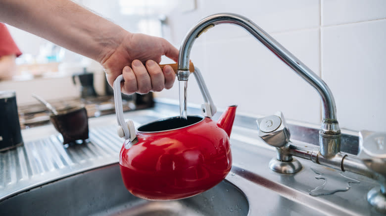 Man filling kettle with water