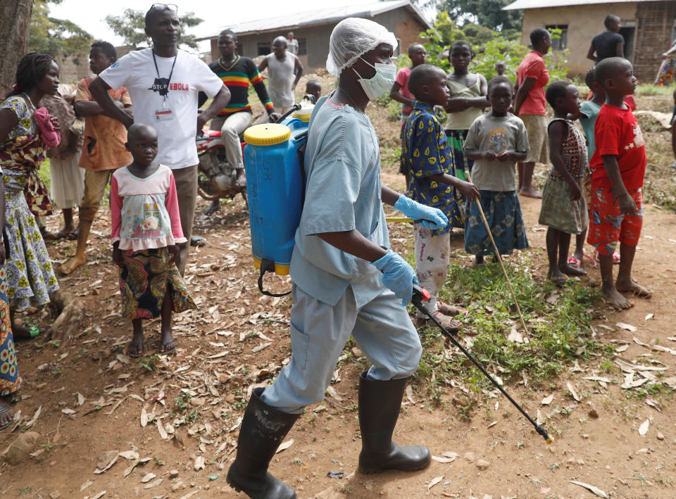 Un trabajador rocía las cercanías de la casa de un sospechoso de tener ébola en República Democrática del Congo (REUTERS/Goran Tomasevic).