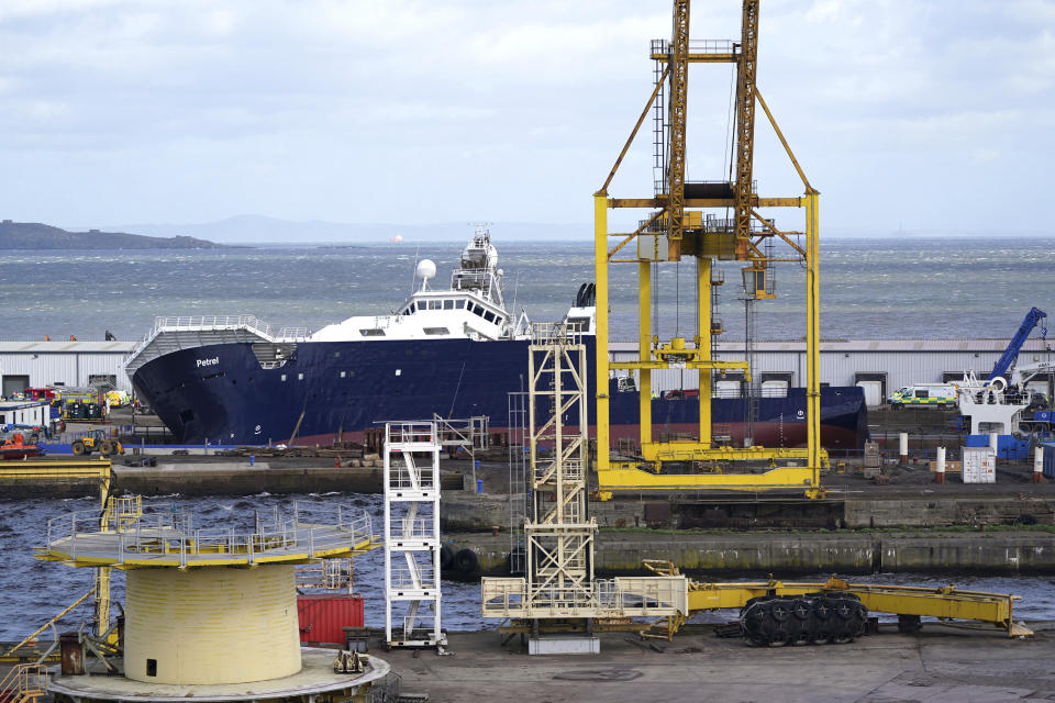 Emergency services work at Imperial Dock, where a ship has become dislodged from its holding and is partially toppled over, in Leith, Edinburgh, Scotland, Wednesday March 22, 2023. (Andrew Milligan/PA via AP)