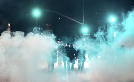 Police officers deploy teargas while trying to disperse a crowd comprised largely of student protesters during a protest against police violence in the U.S., in Berkeley, California early December 7, 2014. REUTERS/Noah Berger