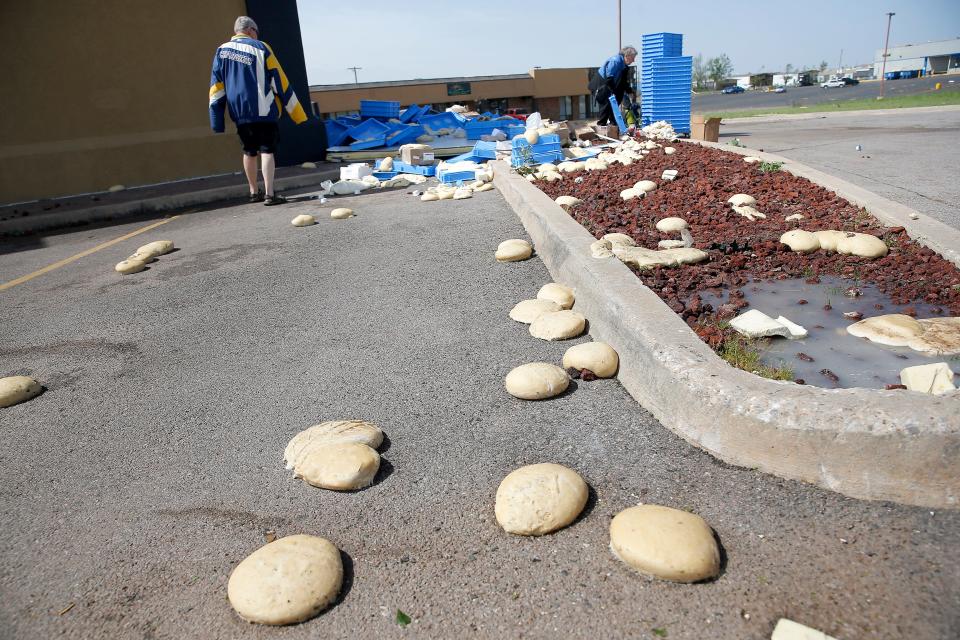 Workers pick up dough balls Thursday at a Domino's Pizza store on Kickapoo Street in Shawnee after severe storms and tornadoes moved through the area Wednesday night.