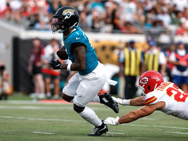 <p>Don Juan Moore/Getty Images</p> Runningback Travis Etienne Jr. #1 of the Jacksonville Jaguars avoids getting tackled by Linebacker Drue Tranquill #23 of the Kansas City Chiefs during a preseason game.