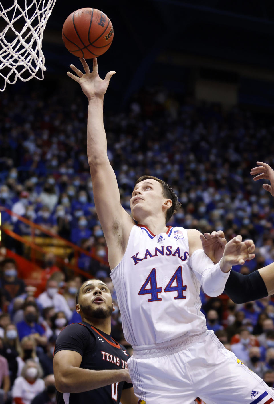 Kansas forward Mitch Lightfoot (44) scores against Texas Tech forward Kevin Obanor (0) during the first half of an NCAA college basketball game on Monday, Jan. 24, 2022 in Lawrence, Kan. (AP Photo/Colin E. Braley)