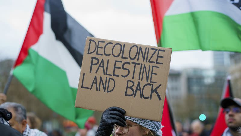 A rally participant holds up a sign “Decolonize Palestine Land Back” on Dec. 23, 2023, in Frankfurt, Germany. Several hundred people demonstrate under the slogan “Stop the genocide in Gaza! Stop the occupation of Palestine!” 