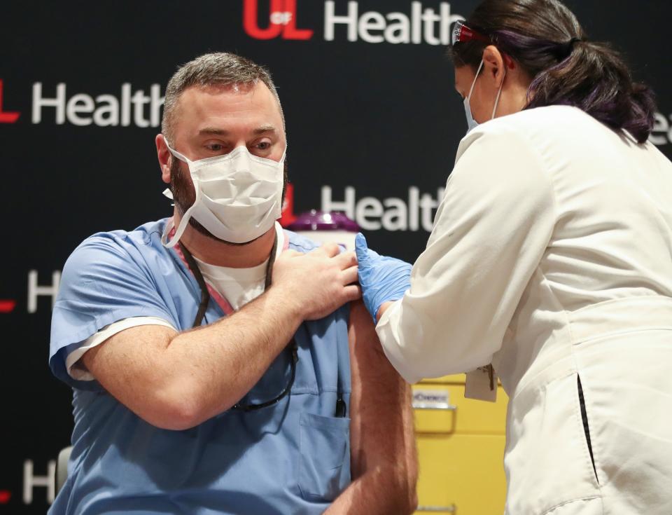 Dr. Jason Smith, chief medical officer and trauma surgeon at U of L hospital, is the first to receive the Pfizer COVID-19 vaccine in the state of Kentucky on Dec. 14, 2020. The shot was administered by nurse Sarah Bishop at U of L Hospital.