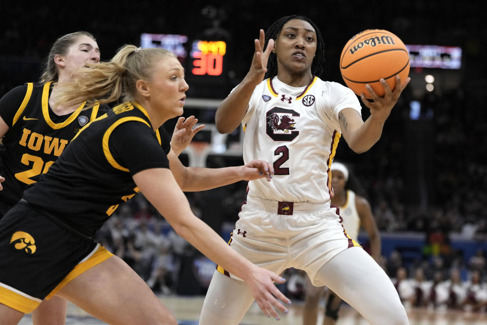 South Carolina forward Ashlyn Watkins (2) fights for a rebound with Iowa guard Sydney Affolter, left, during the first half of the Final Four college basketball championship game in the women's NCAA Tournament, Sunday, April 7, 2024, in Cleveland. (AP Photo/Morry Gash)