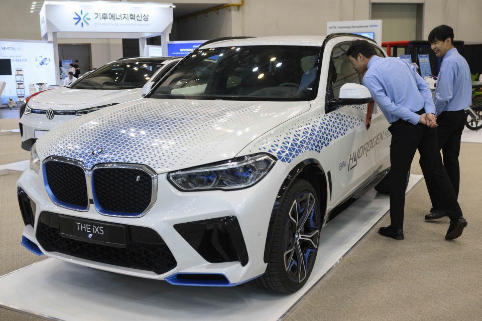 <p>ANTHONY WALLACE / AFP via Getty Images</p> Attendees look at a BMW iX5 Hydrogen Fuel Cell Powered SUV car at the World Climate Industry Expo (2024 WCE) held at BEXCO in Busan, South Korea, on Sept. 4, 2024.