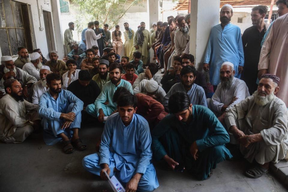 Detained Afghan refugees sit at a police station in Karachi on November 2, 2023, following a police operation against illegal Afghan immigrants. (AFP via Getty Images)