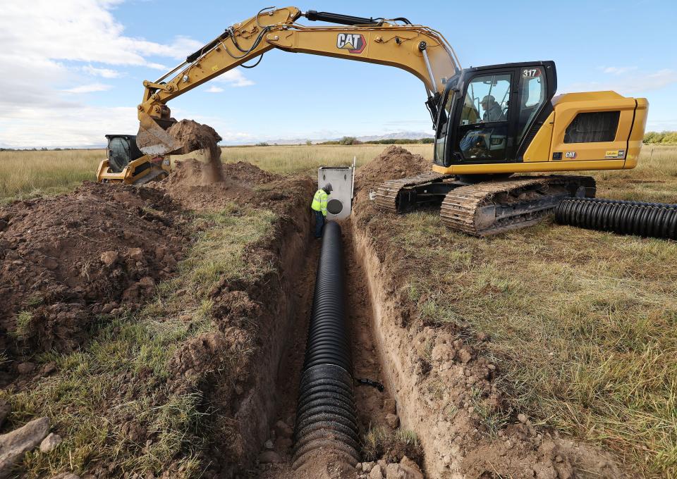 Austin Thomas and Travis Call install some of the 3,000 feet of irrigation pipeline to replace ditches on the New Harvey pastures in Davis County on Wednesday, Oct. 11, 2023. The Nature Conservancy in Utah is improving the flood irrigation system on the 200 acres that is part of the Great Salt Lake Shorelands Preserve. | Jeffrey D. Allred, Deseret News