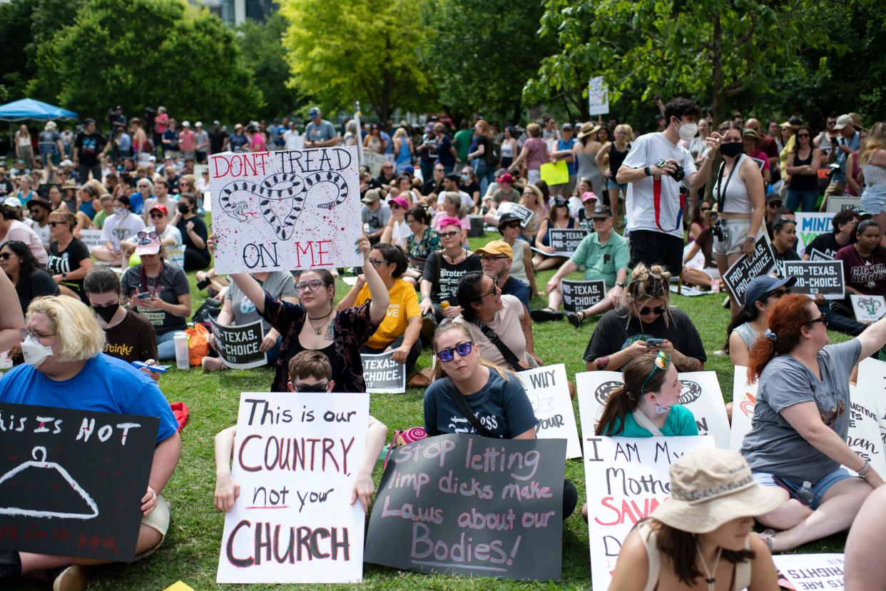 Attendees hold up signs before a Texas Rally for Abortion Rights at Discovery Green in Houston on May 7. 