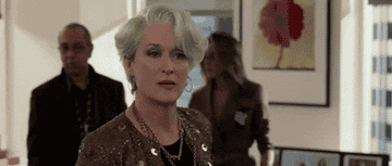 Miranda Priestly, a character from "The Devil Wears Prada," in an office setting looking unimpressed