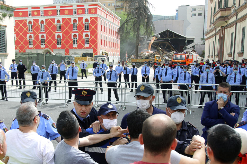 Protesters scuffle with police during the demolition of the national theater building in Tirana, Sunday, May 17, 2020. The government's decision to destroy the old National Theater, built by Italians when they occupied Albania during World War II, was opposed by artists and others who wanted it renovated instead. (AP Photo/Gent Onuzi)