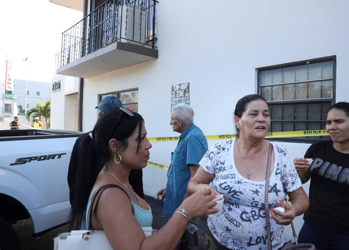 Maria Magdalena Hernandez, 61, center, hands out coffee to fellow residents while they wait outside for answers after a walkway on the second floor collapsed that morning and their building on Palm Avenue was deemed unsafe on Monday, Oct. 31, 2022, in Hialeah.
