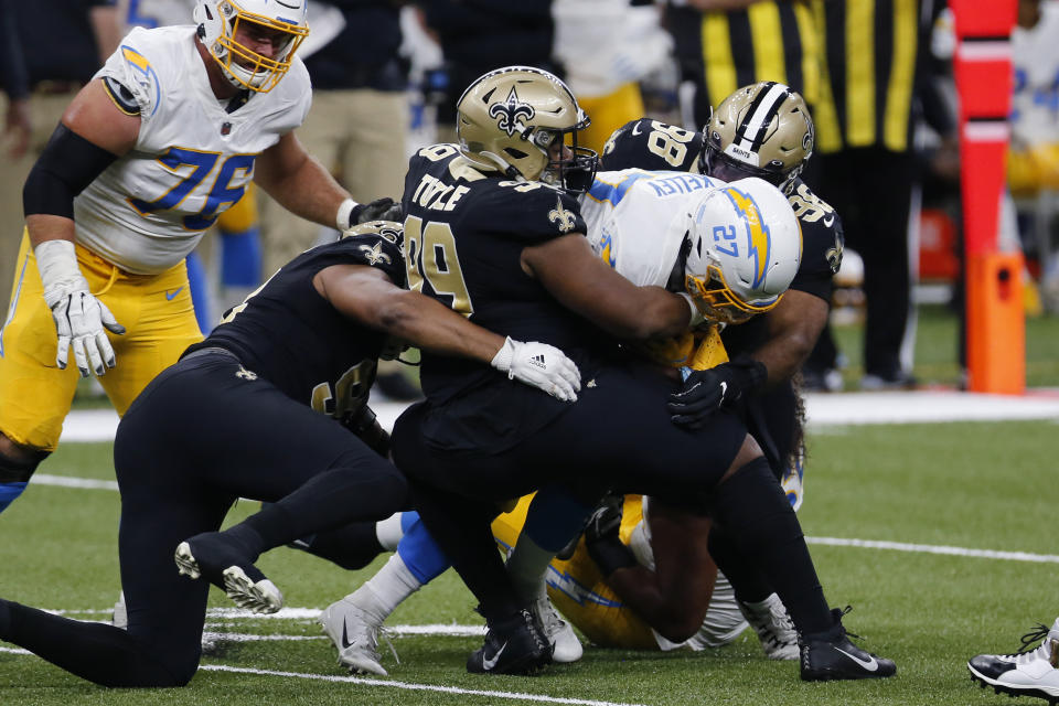 Los Angeles Chargers running back Joshua Kelley (27) is stopped by New Orleans Saints defensive tackle Shy Tuttle (99) and defensive tackle Sheldon Rankins (98) in the first half of an NFL football game in New Orleans, Monday, Oct. 12, 2020. (AP Photo/Brett Duke)