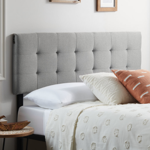 light grey diamond tufted mid-rise headboard with pillows and white comforter