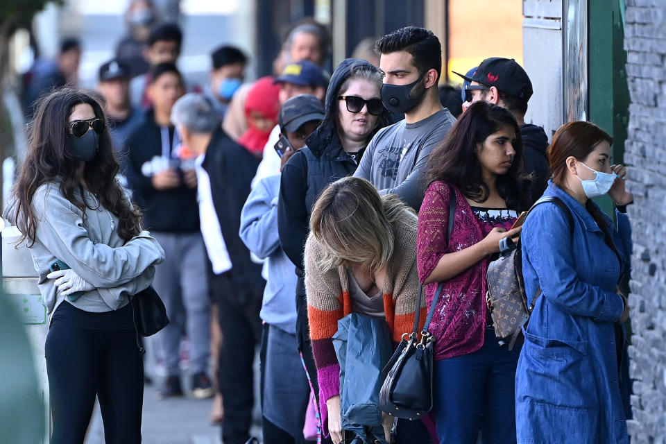 MELBOURNE, AUSTRALIA - MARCH 24: Peopler queue to enter Centrelink on March 24, 2020 in Melbourne, Australia. Non-essential travel has been banned in a bid to stop the spread of COVID-19 in Australia while venues such as bars, clubs, nightclubs, cinemas, gyms and restaurants, along with anywhere people remain static are now closed. Schools are currently open but parents have the option to keep children at home if they wish. There are now 1887 confirmed cases of COVID-19 in Australia and the death toll now stands at eight. (Photo by Quinn Rooney/Getty Images)