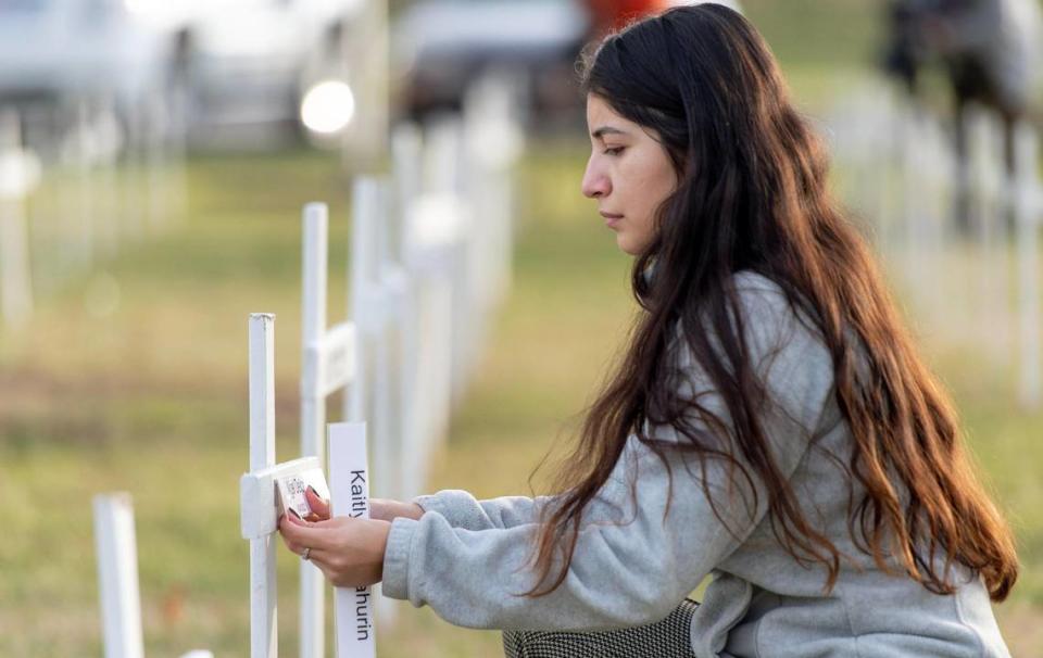 Emily Carballo, a volunteer with KC Mothers in Charge, places a name on a cross on Monday, Dec. 5, 2022, in Independence, Mo. More than 150 crosses were individually marked with the names of this year’s homicide victims.