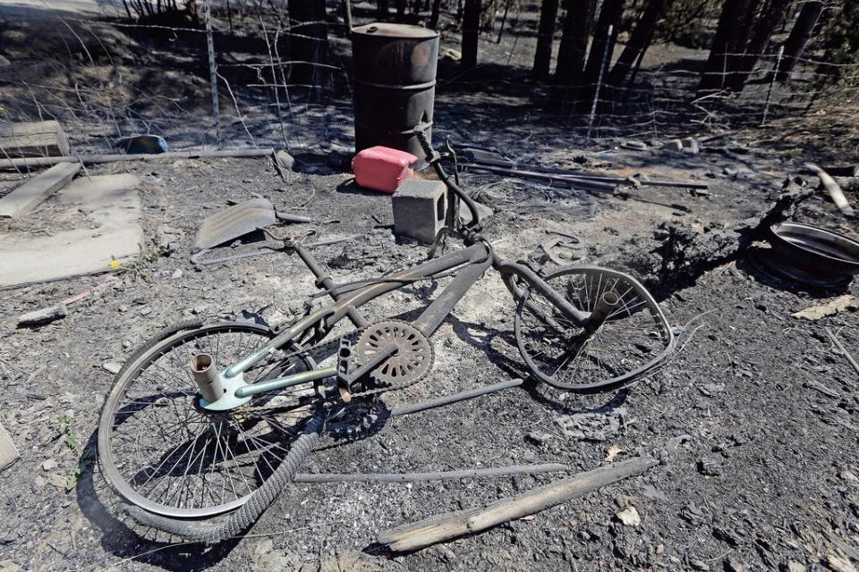 A burnt bicycle is among the remains of a burnt mobile home in the community of San Ignacio following a wildfire near Las Vegas, New Mexico, on Tuesday, May 10, 2022.