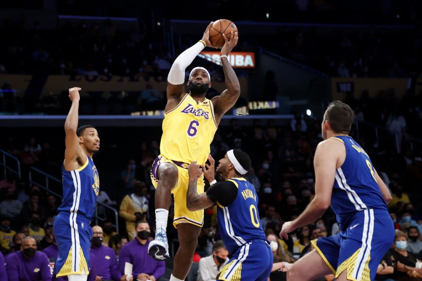 Los Angeles Lakers forward LeBron James shoots over Golden State Warriors guard Gary Payton II, second from right, during the first half of a preseason NBA basketball game in Los Angeles, Tuesday, Oct. 12, 2021. (AP Photo/Ringo H.W. Chiu)