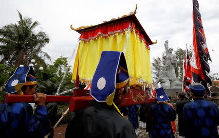 Vietnamese villagers, wearing traditional costume, carry a shrine past the monument during the 50th anniversary of the My Lai massacre in My Lai village, Vietnam March 15, 2018. REUTERS/Kham