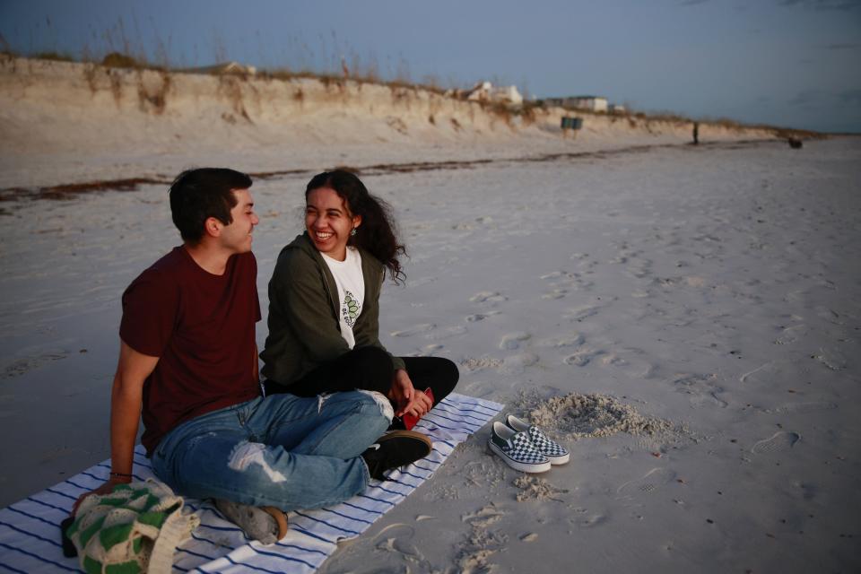 Maddie Lopez, right, laughs with boyfriend Sam Castro as they wait to watch the sun rise Wednesday near 18th Street in Atlantic Beach. The oceanfront city recently passed a ban on smoking at the beach and in parks, citing environmental and health reasons. The state on July 1 lifted a prohibition that kept cities from making such laws against smoking.