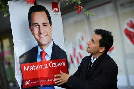 Mahmut Oezdemir of the Social Democratic party SPD adjusts his election campaign poster in Marxloh a suburb of Germany's rust-belt city Duisburg, Germany, September 13, 2017. REUTERS/Wolfgang Rattay