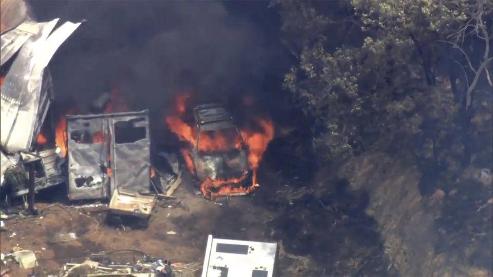 This image made from video shows a car on fire outside Perth, Australia, Thursday, Dec. 21, 2023. A wildfire burning out of control on the outskirts of the Australian west coast city of Perth on Thursday appeared to have destroyed or damaged a number of homes. (Australian Broadcasting Corp/Channel 7/Channel 9 via AP)