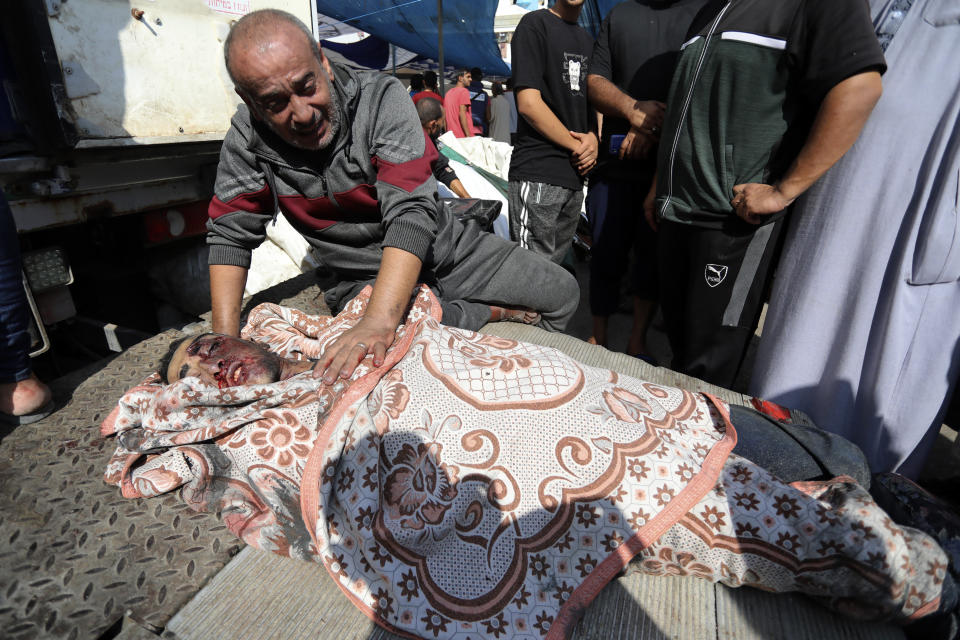 A Palestinian man mourns over the body of his relative who was killed in an Israeli airstrike, in the al-Shifa hospital in Gaza City, Sunday, Nov. 5, 2023. (AP Photo/Abed Khaled)