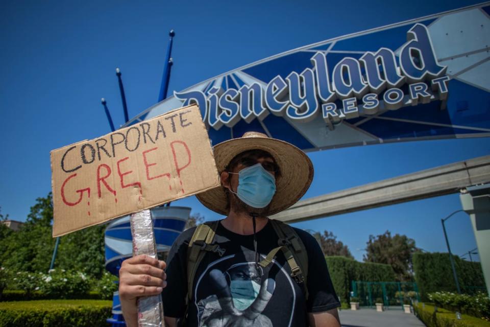 <div class="inline-image__caption"><p>A man holds a sign in front of Disneyland Resort calling for higher safety standards before its reopening July 17, amid the coronavirus pandemic in Anaheim, California on June 27, 2020. </p></div> <div class="inline-image__credit">Apu Gomes/AFP/Getty</div>