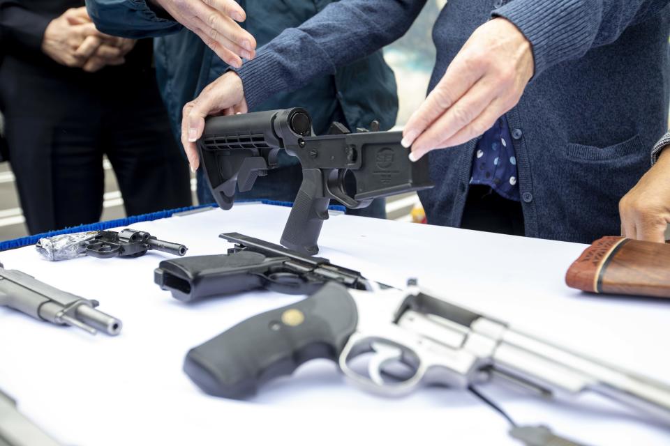 A bump stock and handguns collected during a buyback event in Los Angeles on Saturday, March 4, 2023.  / Credit: Bloomberg