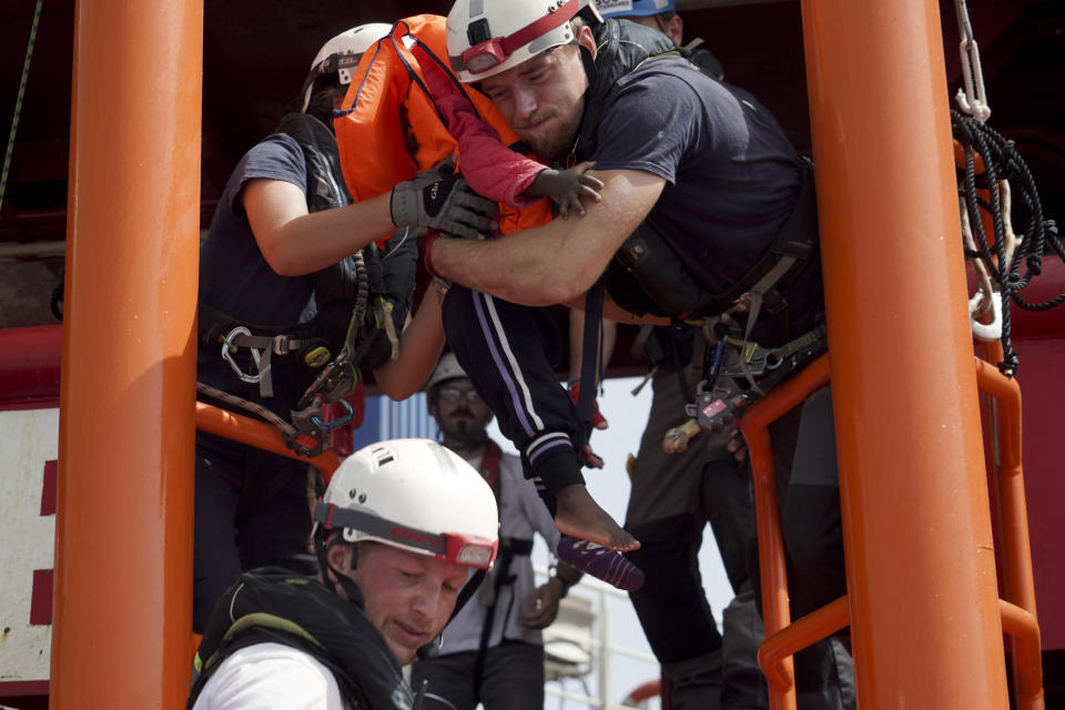 A little girl is carried onto the Ocean Viking humanitarian rescue ship after a rescue operation some 53 nautical miles (98 kilometers) from the coast of Libya in the Mediterranean Sea, Tuesday, Sept. 17, 2019. The humanitarian rescue ship Ocean Viking pulled 48 people from a small overcrowded wooden boat including a newborn and a pregnant woman. (AP Photo/Renata Brito)