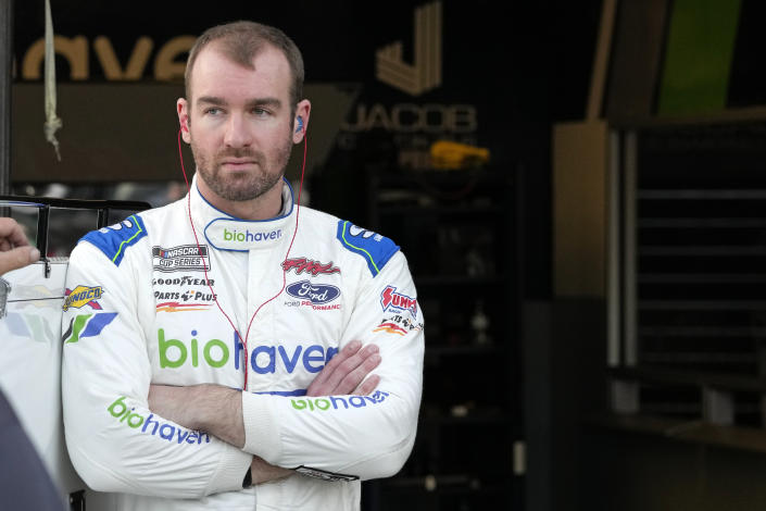 Cody Ware stands outside his garage as crew members work on the car during a practice session for the NASCAR Daytona 500 auto race at Daytona International Speedway, Friday, Feb. 17, 2023, in Daytona Beach, Fla. (AP Photo/John Raoux)