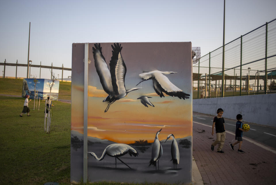 Children play in a park near a painted concrete bomb shelter, in Sderot, Israel, July 20, 2021. No place in Israel has been hit harder by Palestinian rocket fire than Sderot, a working-class town just about a mile (1.5 kilometers) from the Gaza border. Although Sderot is enjoying an economic boom and revival, a generation of children and parents are suffering from the traumatic effects of two decades of rocket fire that experts are still struggling to understand. (AP Photo/Ariel Schalit)