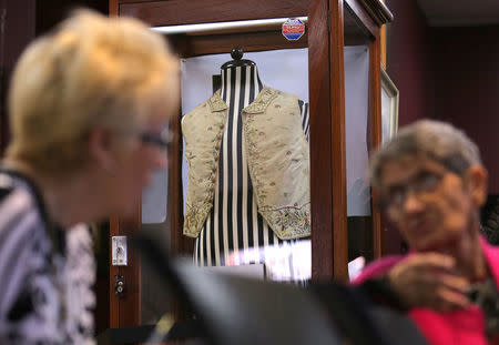 Potential buyers are be seen near the display case containing a 250-year-old embroidered silk waistcoat that belonged to Captain James Cook on a mannequin at Aalders Auctions house in Sydney, Australia, March 26, 2017. REUTERS/Steven Saphore