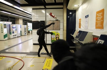 Anti-government protesters vandalize an entrance to the MTR station in Hong Kong