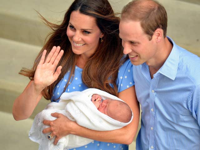 Kate cradles newborn Prince George, who is wrapped in a shawl, outside hospital with William at her side