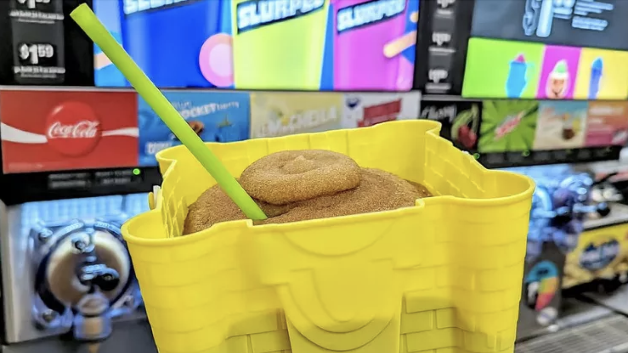 a yellow plastic container with a green straw and a green straw