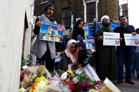 Muslims pray at a floral tribute near London Bridge, after attackers rammed a hired van into pedestrians on London Bridge and stabbed others nearby killing and injuring people, in London, Britain June 4, 2017. REUTERS/Peter Nicholls