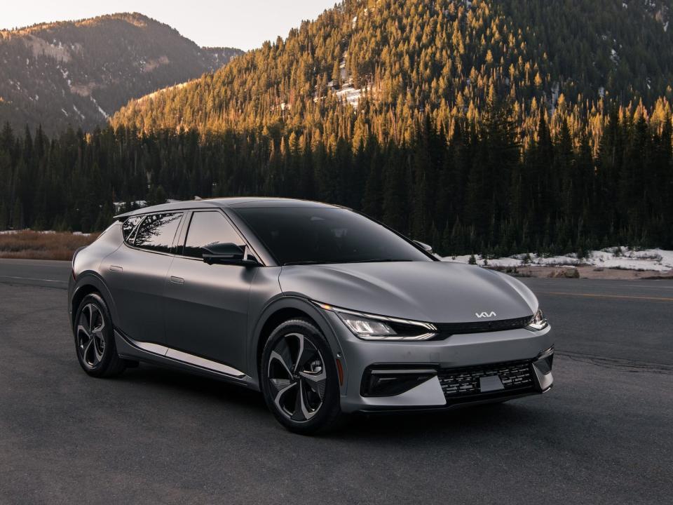 The Kia EV6 parked on a road with mountains in the background.