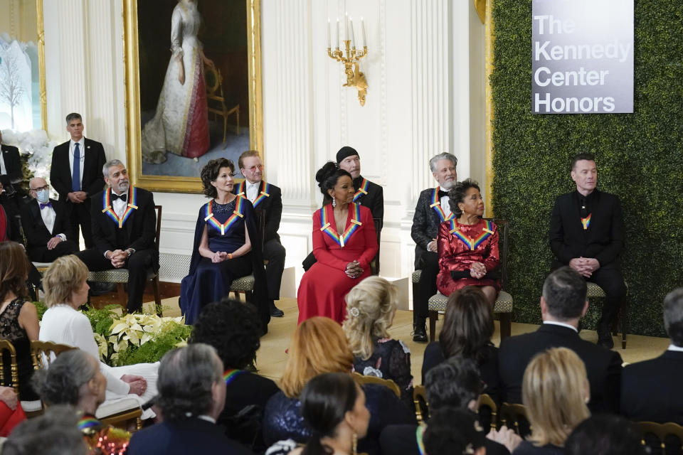 The 2022 Kennedy Center Honorees front row from left, George Clooney, Amy Grant, Gladys Knight, and Tania León, and back row from left, Irish band U2 members Bono, The Edge, Adam Clayton and Larry Mullen Jr. listen as President Joe Biden speaks during the Kennedy Center honorees reception at the White House in Washington, Sunday, Dec. 4, 2022. (AP Photo/Manuel Balce Ceneta)